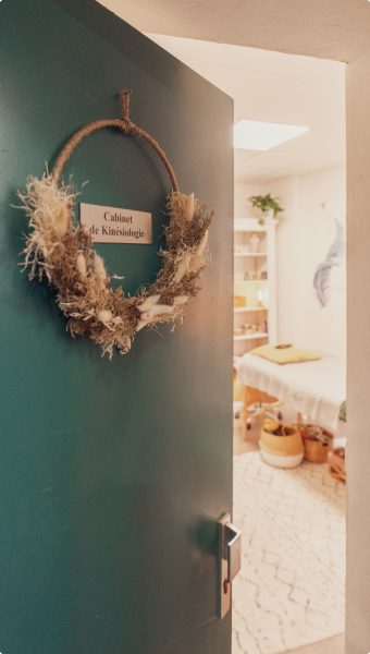 Porte d’un cabinet de kinésiologie ouverte sur une salle de soin accueillante.