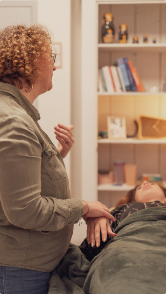 Séance de kinésiologie avec une patiente allongée sur une table de consultation.